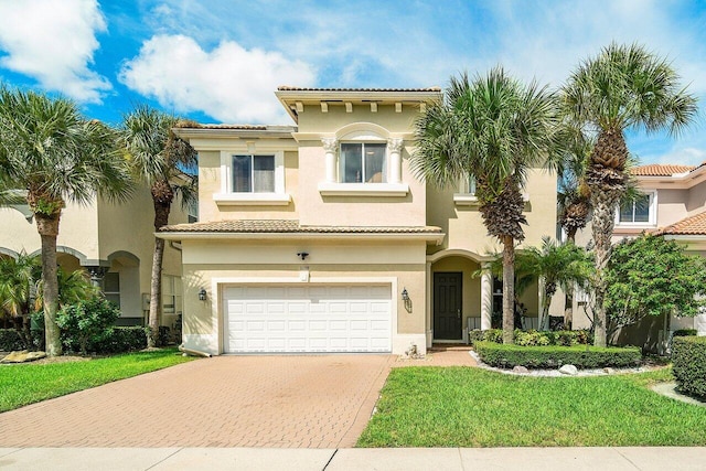 mediterranean / spanish home with a garage and a front yard