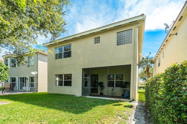 rear view of house featuring a yard