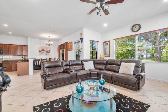 living room with light tile patterned floors, ceiling fan with notable chandelier, and sink