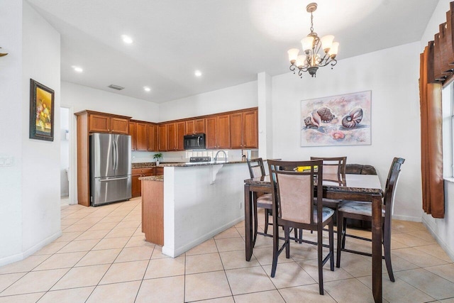 kitchen with pendant lighting, light tile patterned floors, and stainless steel refrigerator