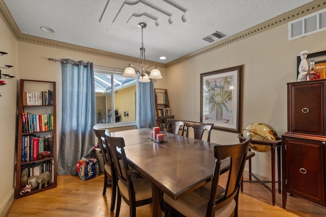 dining room with a notable chandelier, a textured ceiling, and light hardwood / wood-style floors