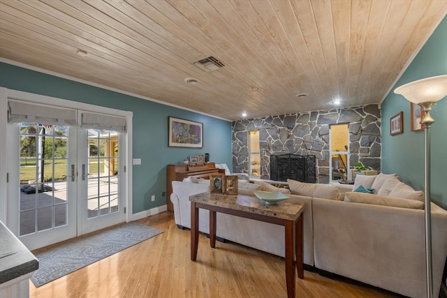 living room featuring crown molding, wood ceiling, a fireplace, french doors, and light wood-type flooring