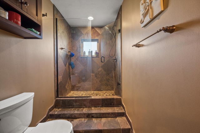 bathroom with toilet and a shower with door