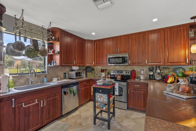 kitchen featuring tasteful backsplash, stainless steel appliances, decorative light fixtures, and sink