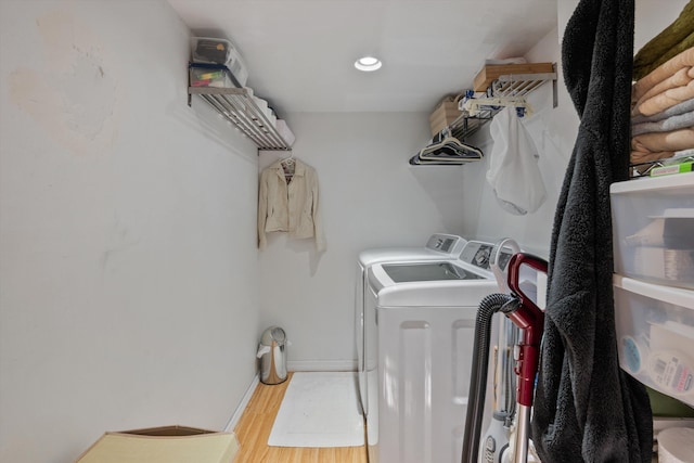 laundry area with separate washer and dryer and hardwood / wood-style flooring