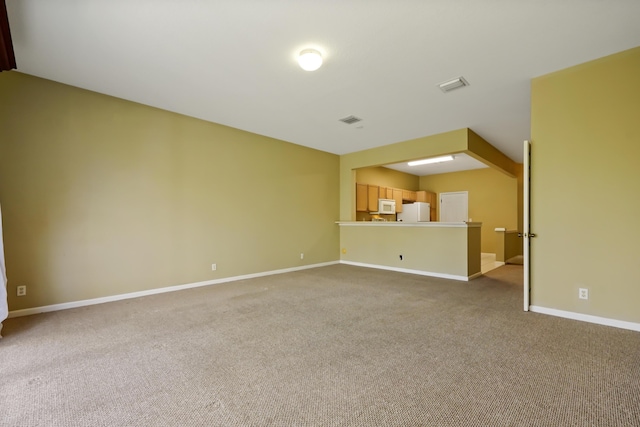 unfurnished living room with light colored carpet