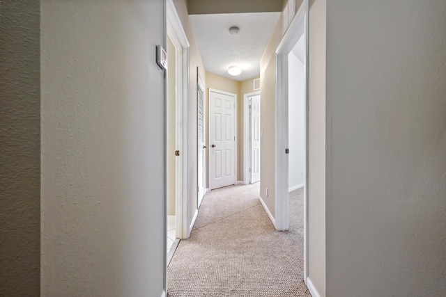 corridor featuring light colored carpet