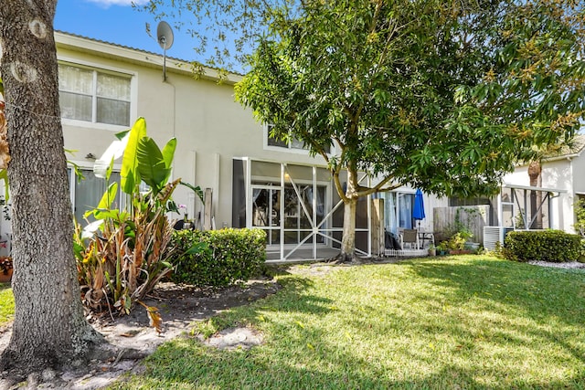 back of house featuring central AC unit and a lawn