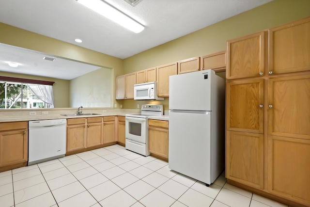 kitchen featuring light tile patterned flooring, white appliances, light brown cabinetry, and sink