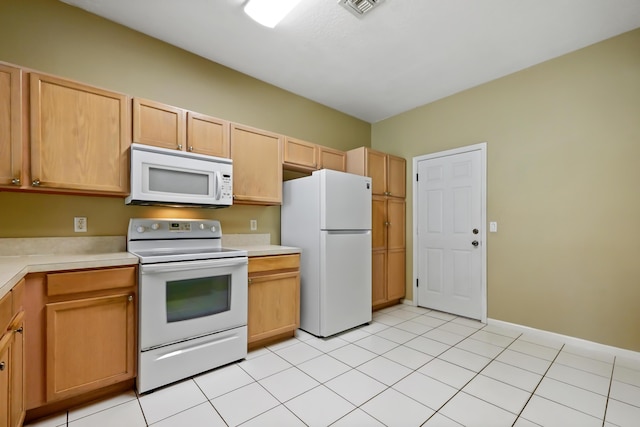 kitchen with light tile patterned floors, white appliances, and light brown cabinets