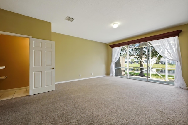 carpeted empty room with a water view