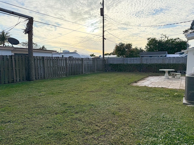 yard at dusk with a patio area and central air condition unit