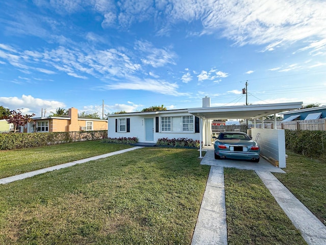 view of front of house with a front lawn and a carport