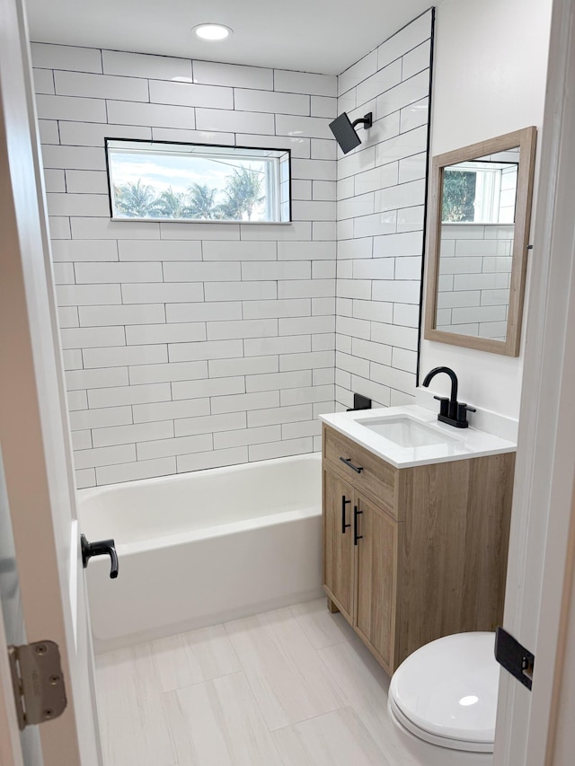 full bathroom with vanity, tiled shower / bath combo, and toilet