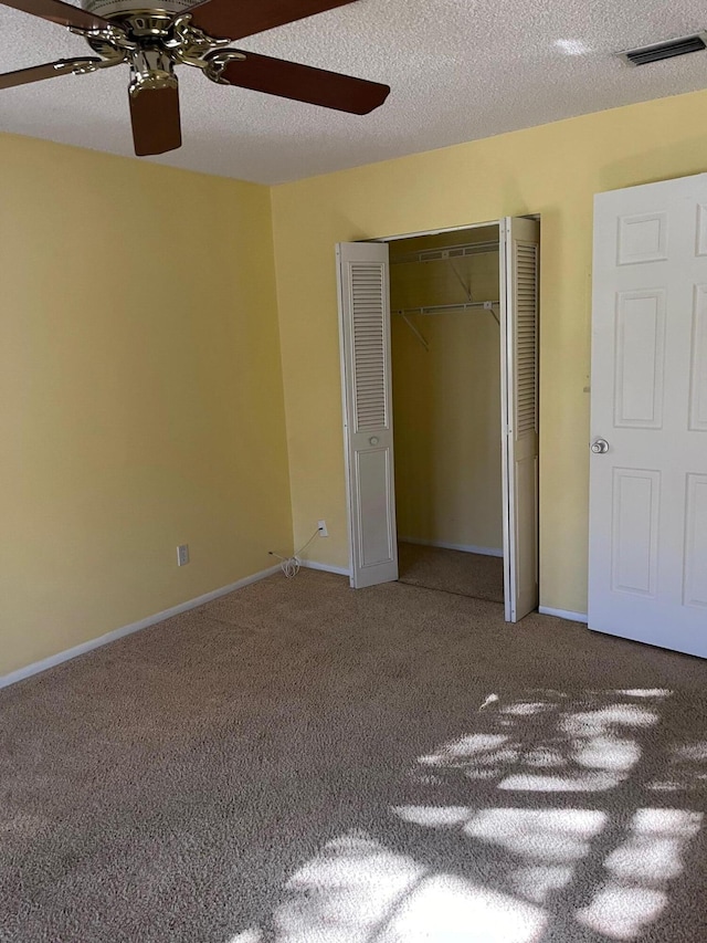 unfurnished bedroom with visible vents, baseboards, carpet flooring, a closet, and a textured ceiling