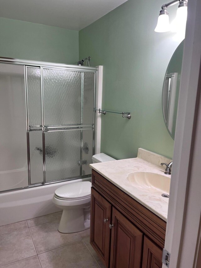 full bathroom featuring vanity, tile patterned floors, toilet, and combined bath / shower with glass door