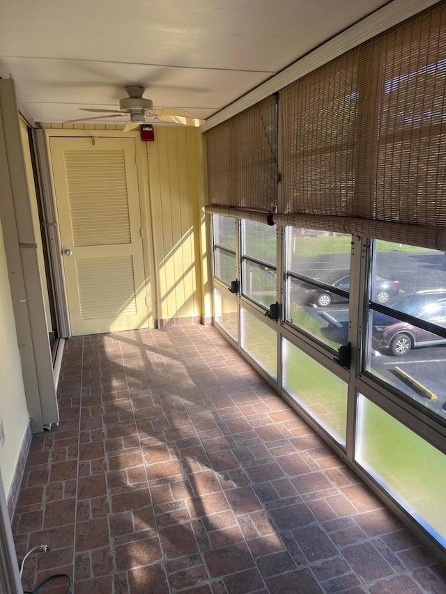 unfurnished sunroom with a ceiling fan