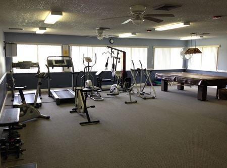 exercise room with a textured ceiling and a ceiling fan