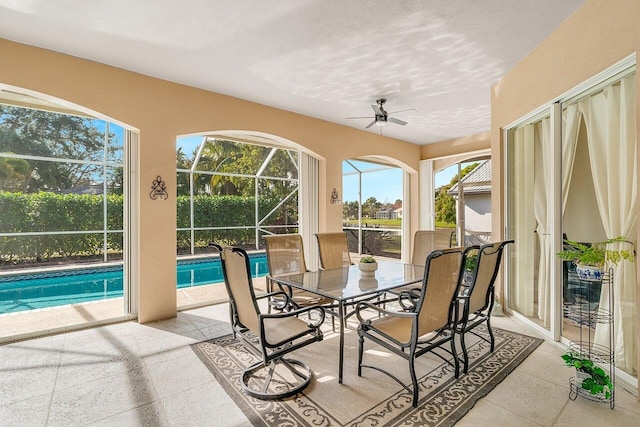 sunroom / solarium featuring ceiling fan and a pool