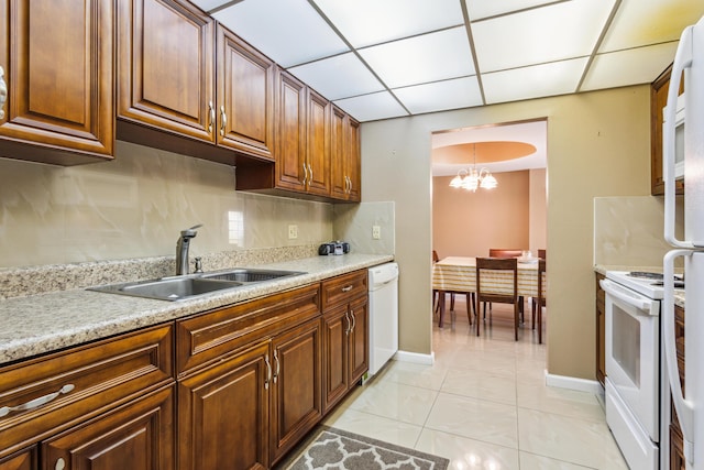 kitchen featuring sink, decorative light fixtures, light tile patterned floors, white appliances, and a drop ceiling