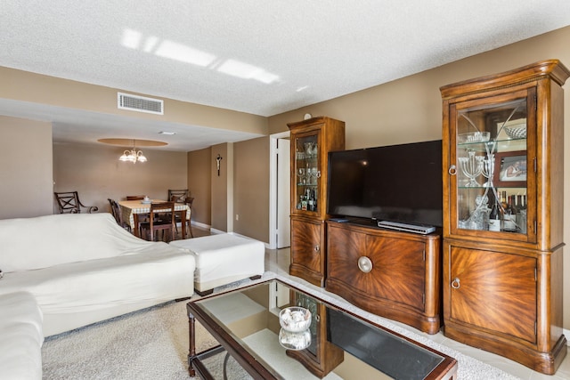 living room featuring a textured ceiling and a notable chandelier