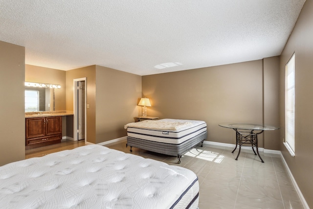 bedroom with connected bathroom and a textured ceiling