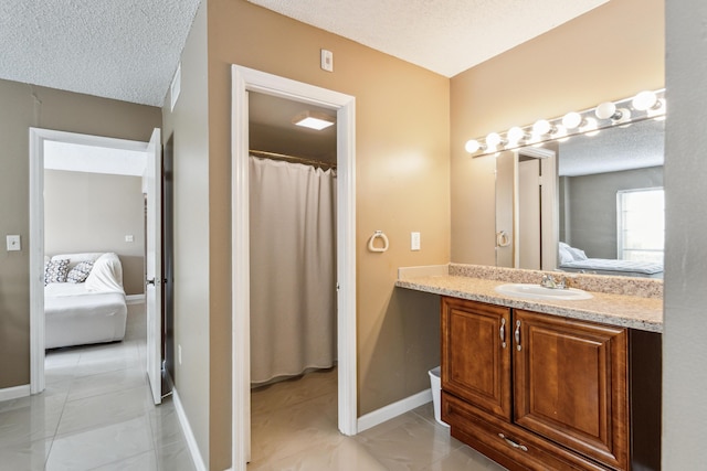 bathroom featuring vanity, a textured ceiling, and tile patterned flooring