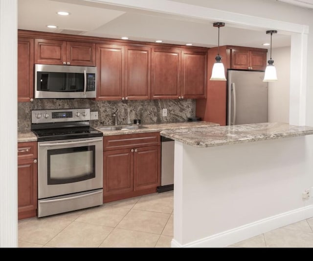 kitchen featuring sink, light stone countertops, kitchen peninsula, and appliances with stainless steel finishes