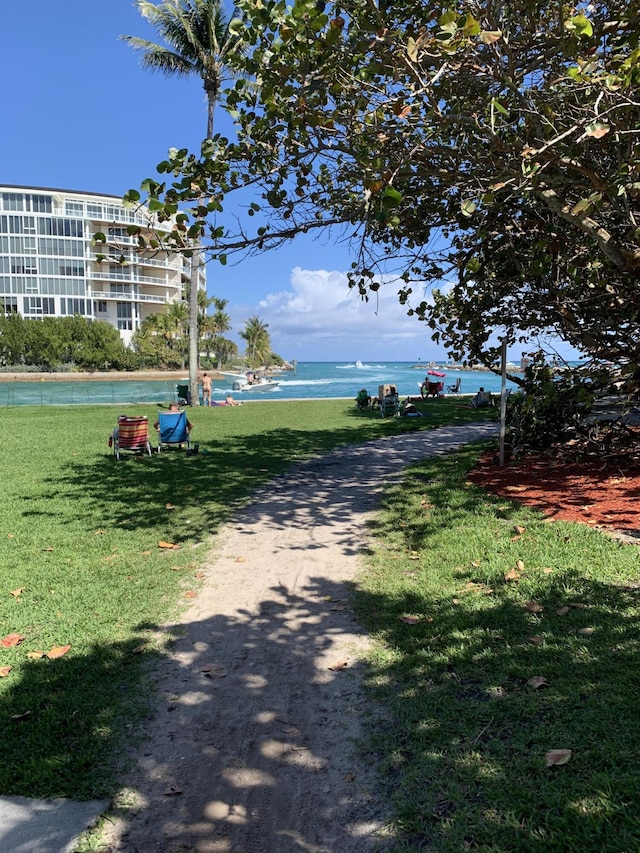 view of property's community with a water view and a yard