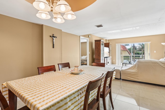 tiled dining room featuring a chandelier