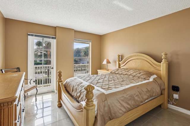 tiled bedroom featuring a textured ceiling and access to exterior