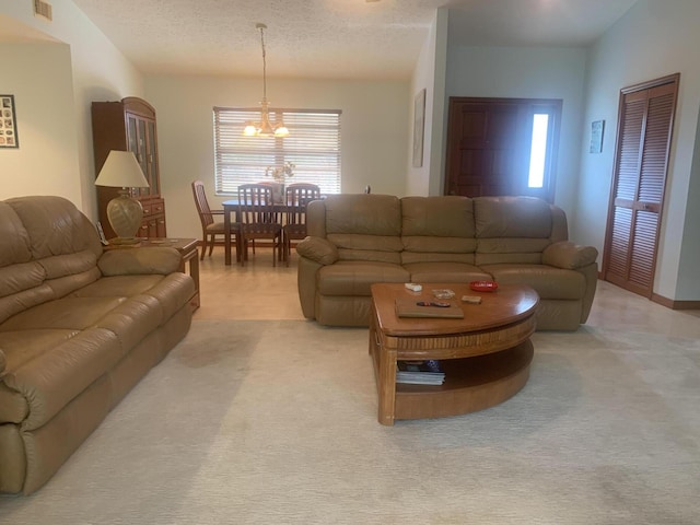 living room featuring an inviting chandelier, light carpet, and a textured ceiling