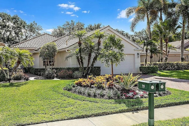 view of front of house with a garage and a front lawn