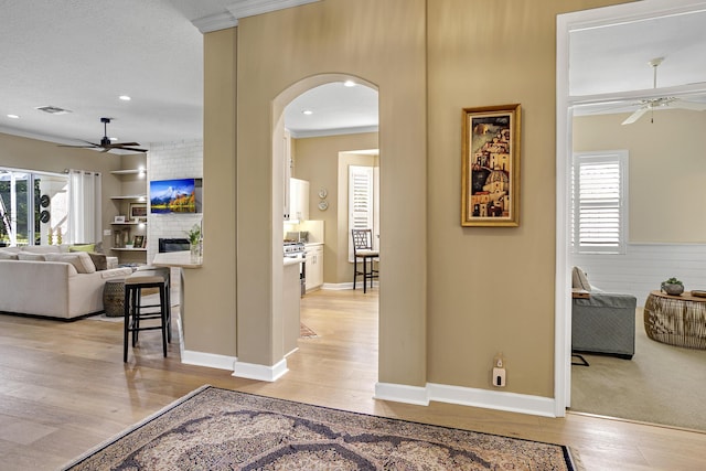 hall with light hardwood / wood-style floors and a textured ceiling