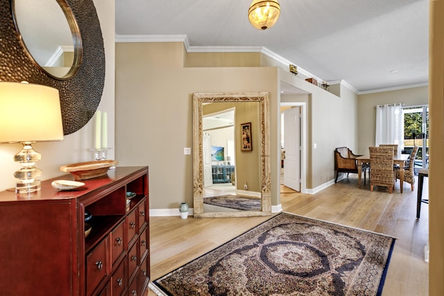 foyer featuring crown molding and light hardwood / wood-style floors