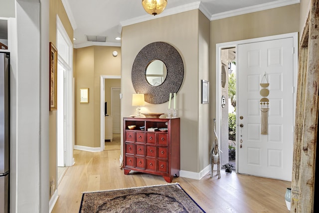 foyer entrance featuring crown molding and light hardwood / wood-style floors