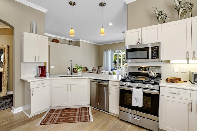 kitchen with sink, white cabinets, hanging light fixtures, ornamental molding, and stainless steel appliances