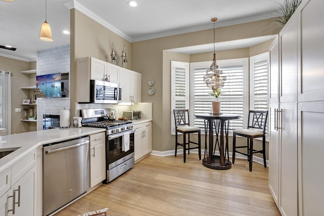 kitchen with stainless steel appliances, white cabinetry, tasteful backsplash, and pendant lighting