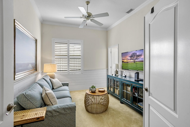 sitting room with ornamental molding, carpet, and ceiling fan