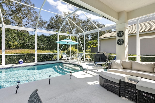 view of pool featuring area for grilling, an outdoor living space, a patio area, and glass enclosure