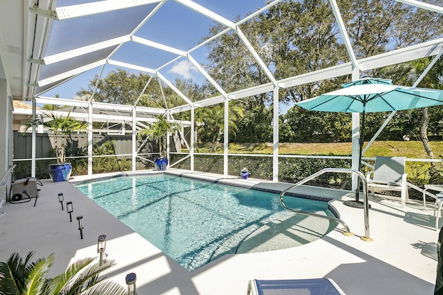 view of pool with a patio area and glass enclosure