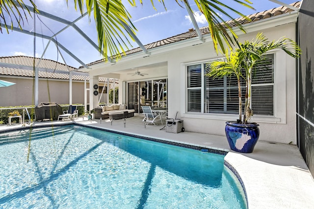 view of pool with outdoor lounge area, ceiling fan, a lanai, and a patio