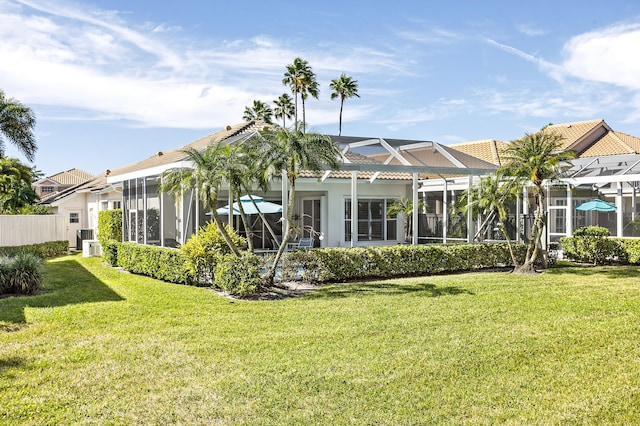 rear view of house with a lanai, a lawn, and central air condition unit