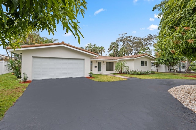 single story home featuring a garage and a front lawn