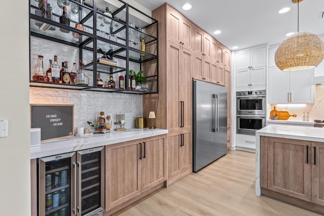 kitchen with light hardwood / wood-style flooring, stainless steel appliances, tasteful backsplash, wine cooler, and white cabinets