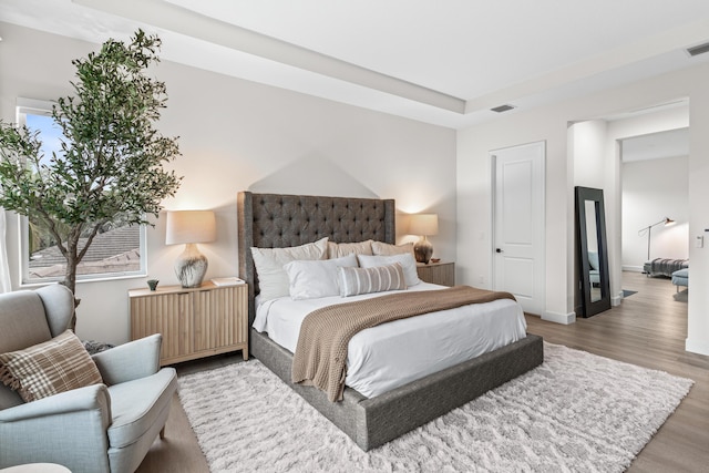 bedroom featuring hardwood / wood-style floors and multiple windows