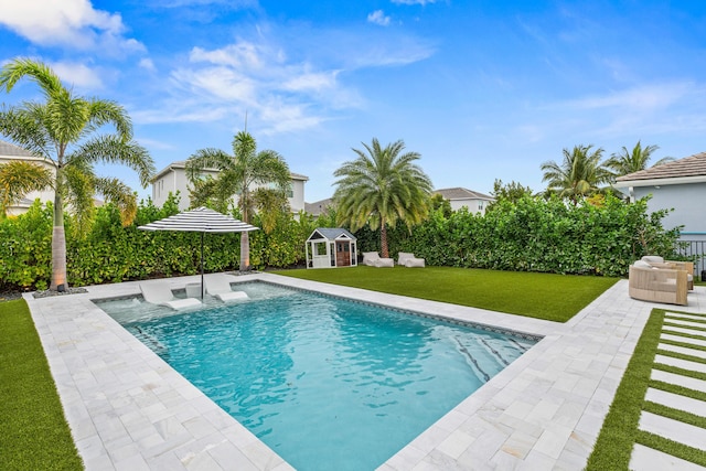 view of pool with a patio, an outdoor structure, and a lawn