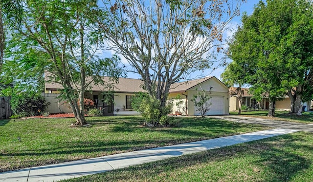 ranch-style house featuring a garage and a front lawn