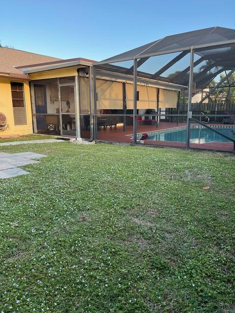 view of yard featuring glass enclosure and a patio area