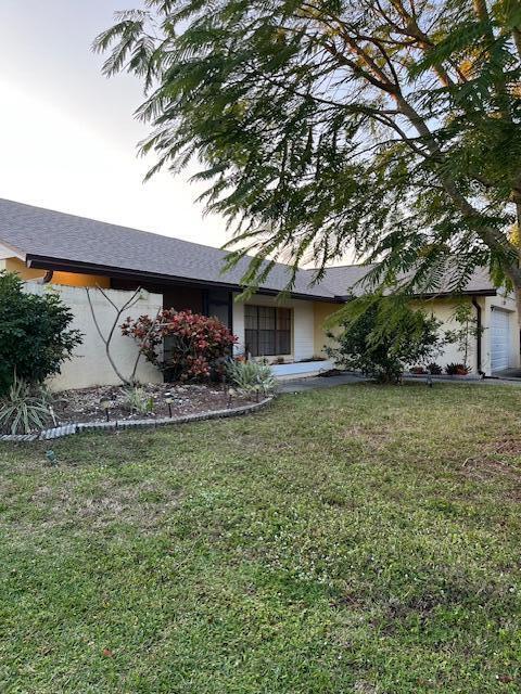 view of front of property with a garage and a front lawn